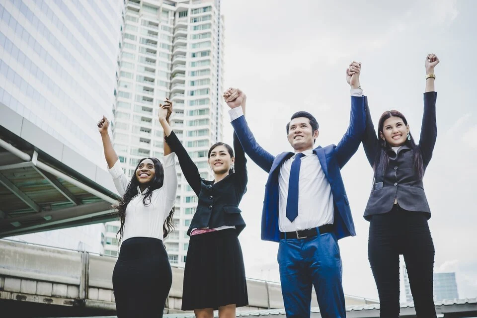 Consultant and happy clients celebrating a successful Mergers and Acquisition Consulting together